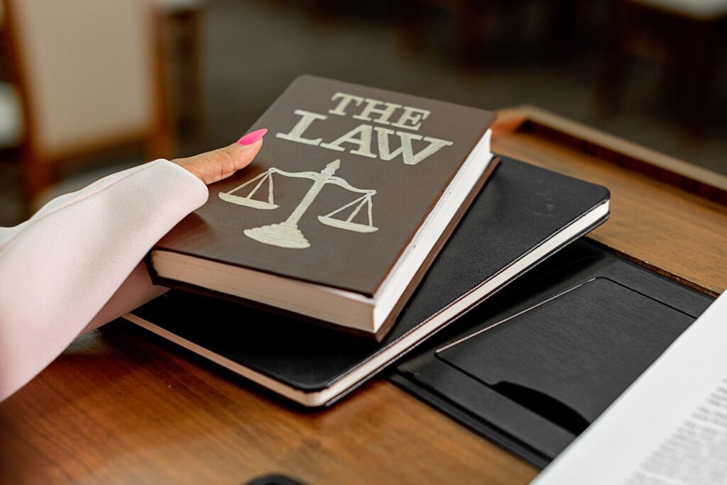 pexels photo 8731037 1 Closeup image of a law book titled 'The Law' on a wooden desk with scales of justice.